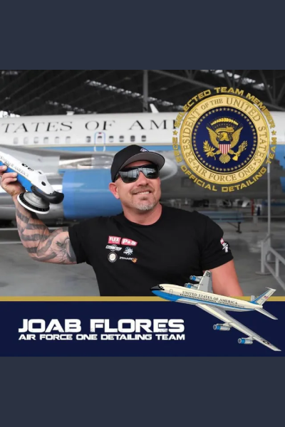 Joab Flores holding a model airplane in front of a U.S. aircraft hangar, with an Air Force seal beside him.