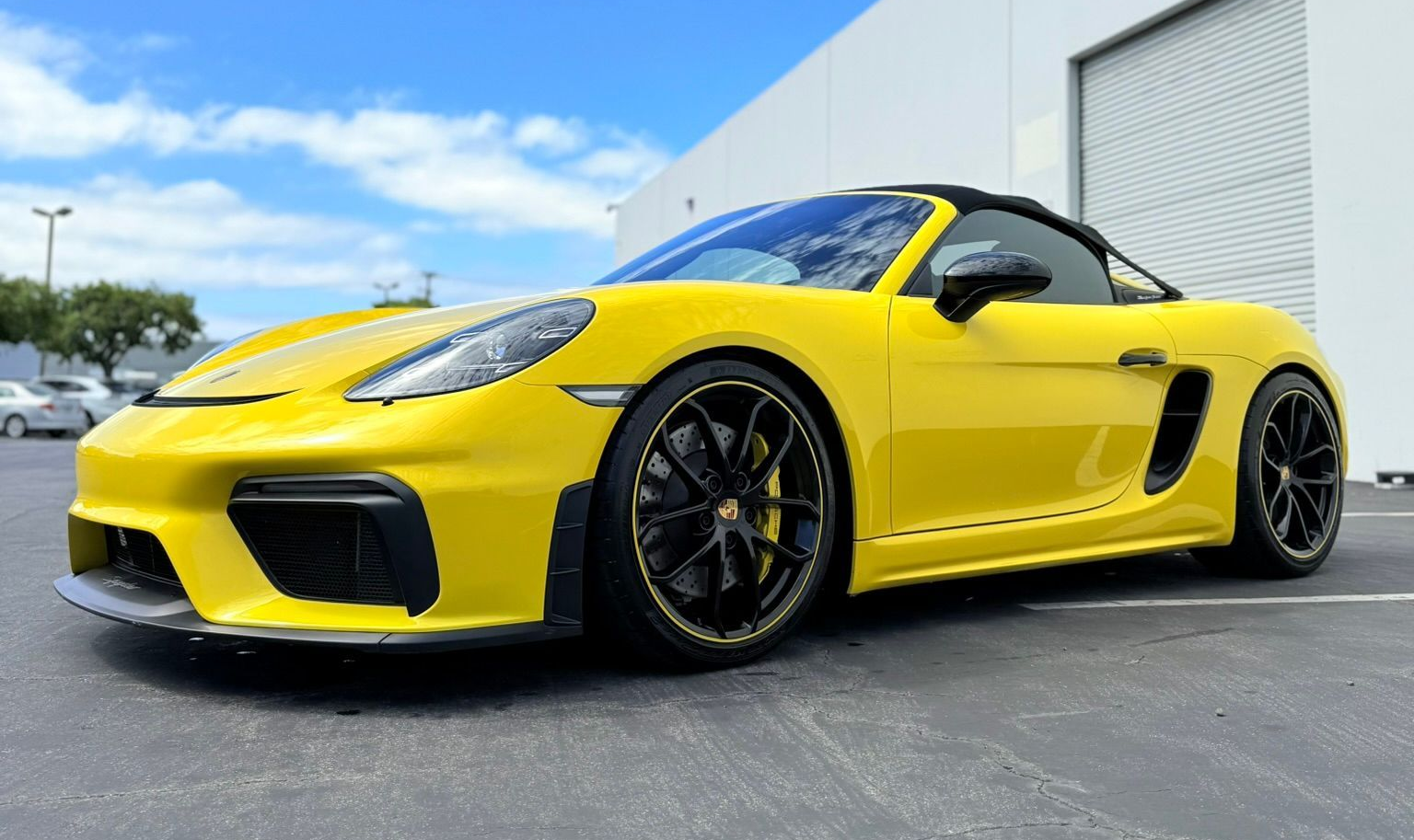 Silver Porsche 911 in a showroom, angled front view with black roof and chrome wheels