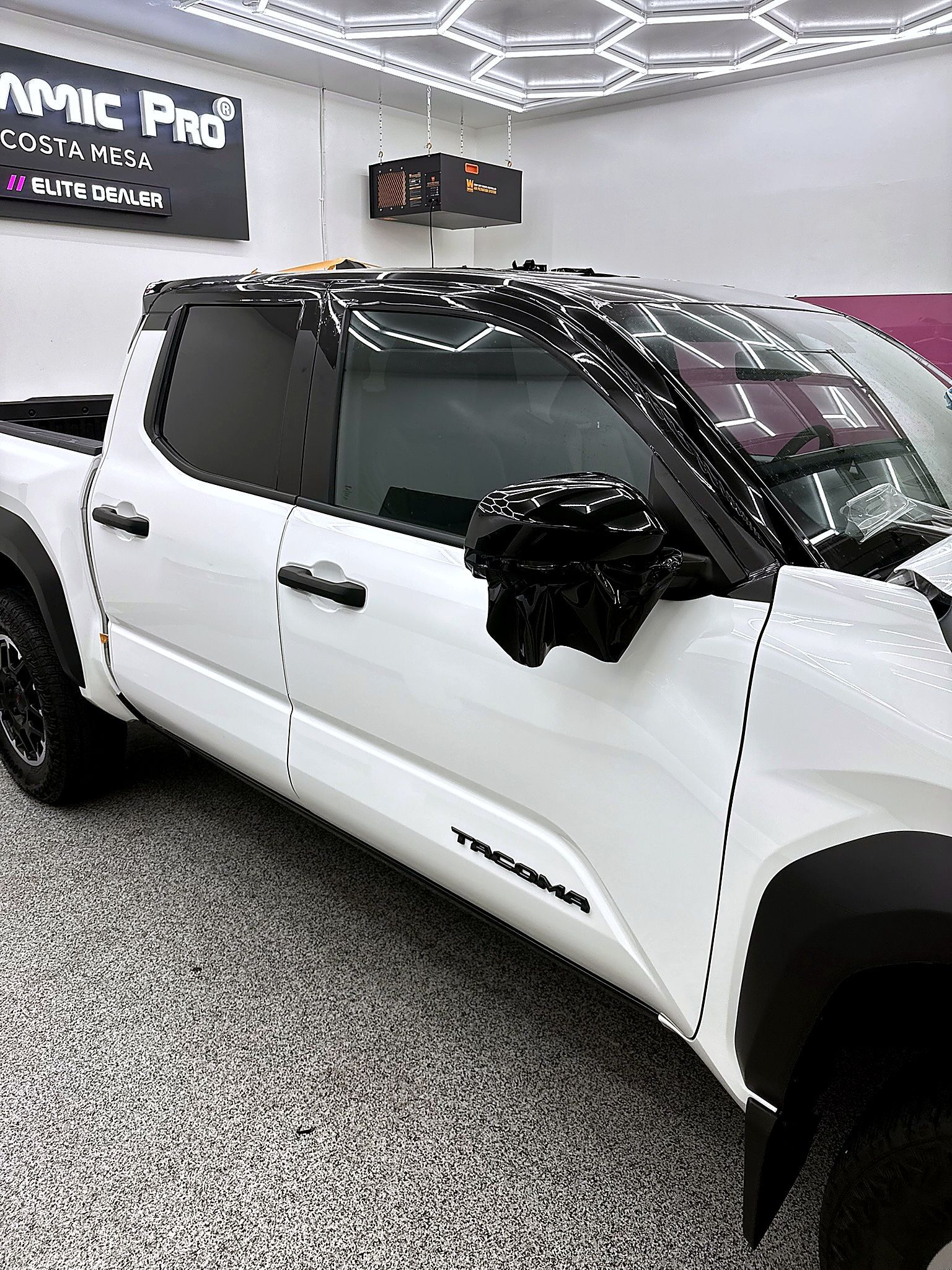 White Chevrolet Tahoe in a showroom with black trim and tinted windows