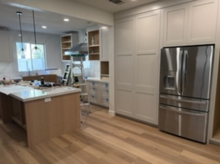 Modern minimalist kitchen with navy cabinets, white backsplash, and warm under-cabinet lighting