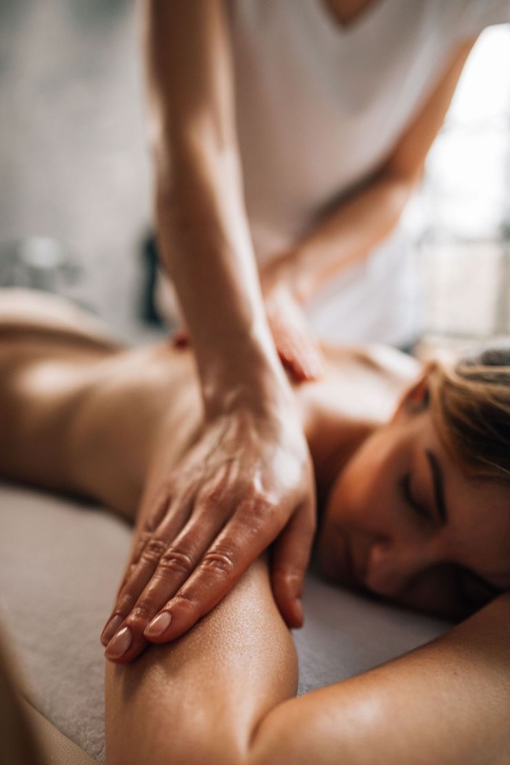 Massage therapist kneading a client’s back during a relaxing spa treatment