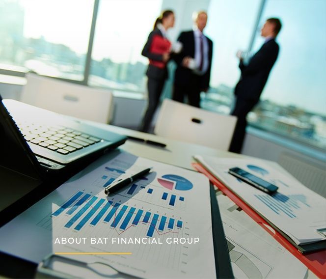 A table with papers and a laptop with the words about b & t financial group on it.