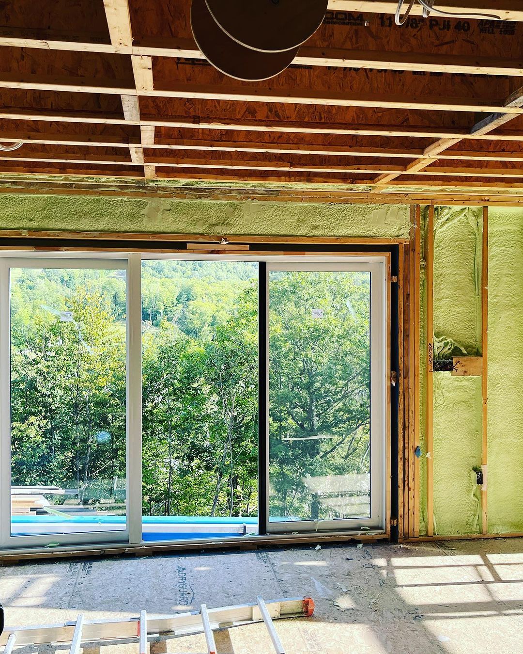 A room with a sliding glass door and trees in the background