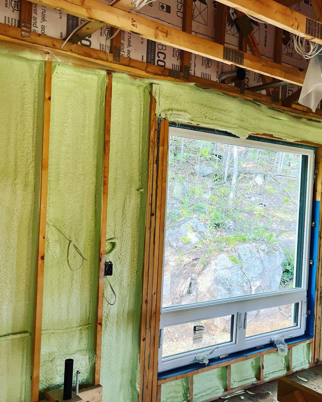 A green wall with a window in the middle of it.