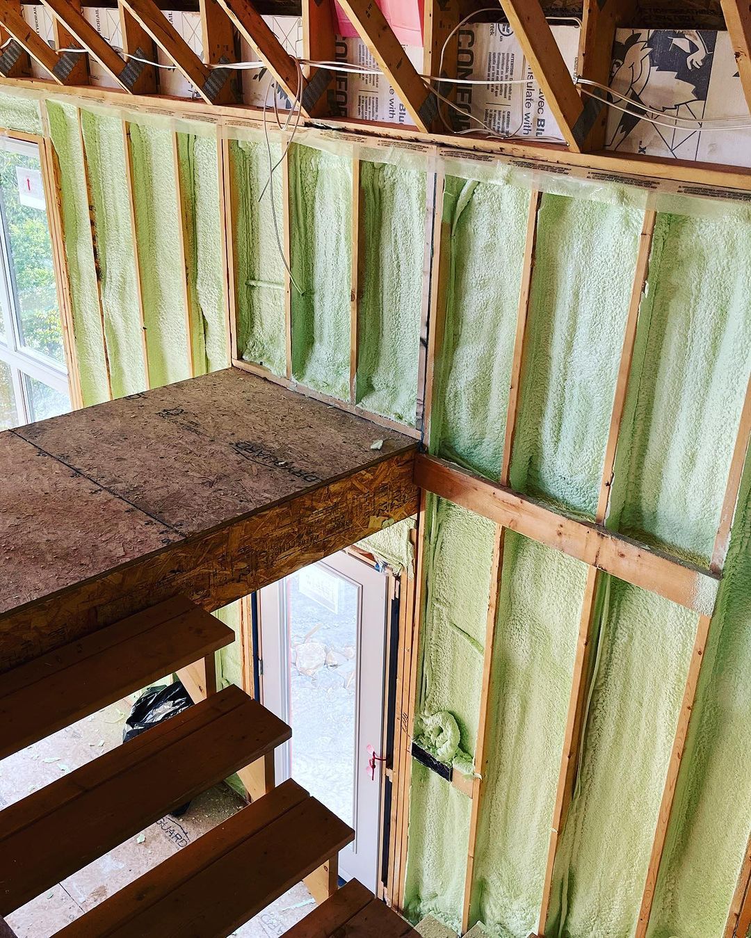 A house is being built with foam insulation on the walls and stairs.