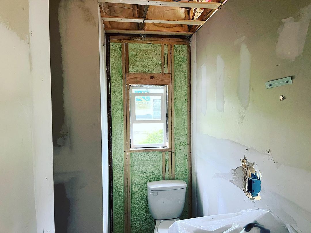 A bathroom under construction with a toilet and a window.
