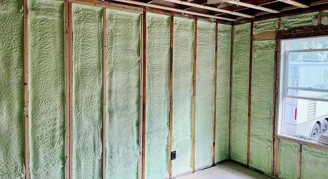 Wall insulation between wooden studs, covering interior walls, near a window.