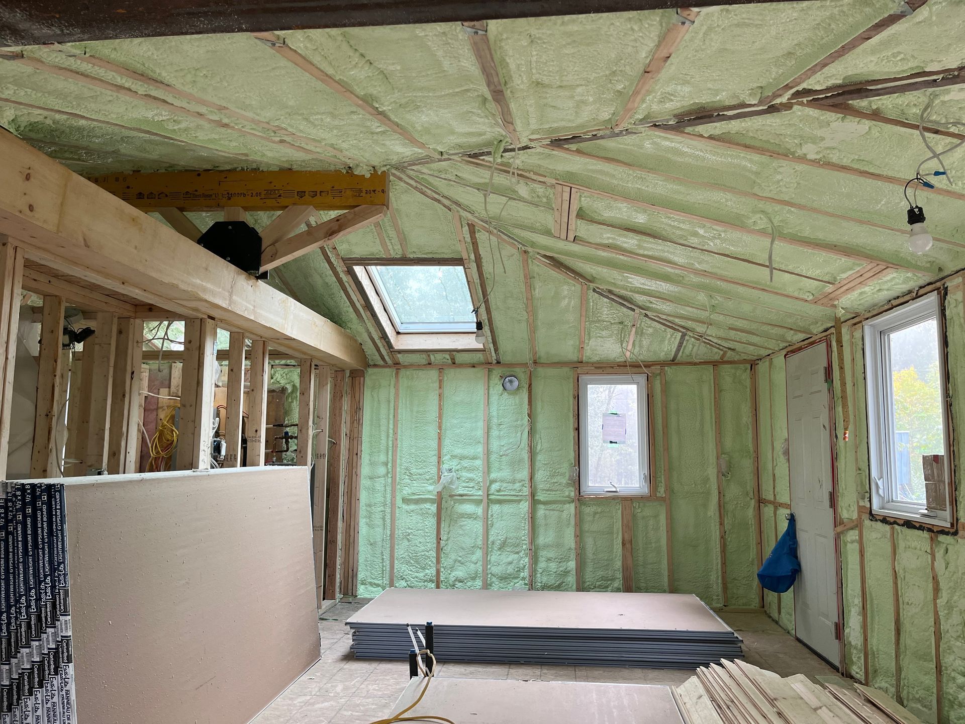 Interior of a house under renovation with fiberglass insulation installed between studs.