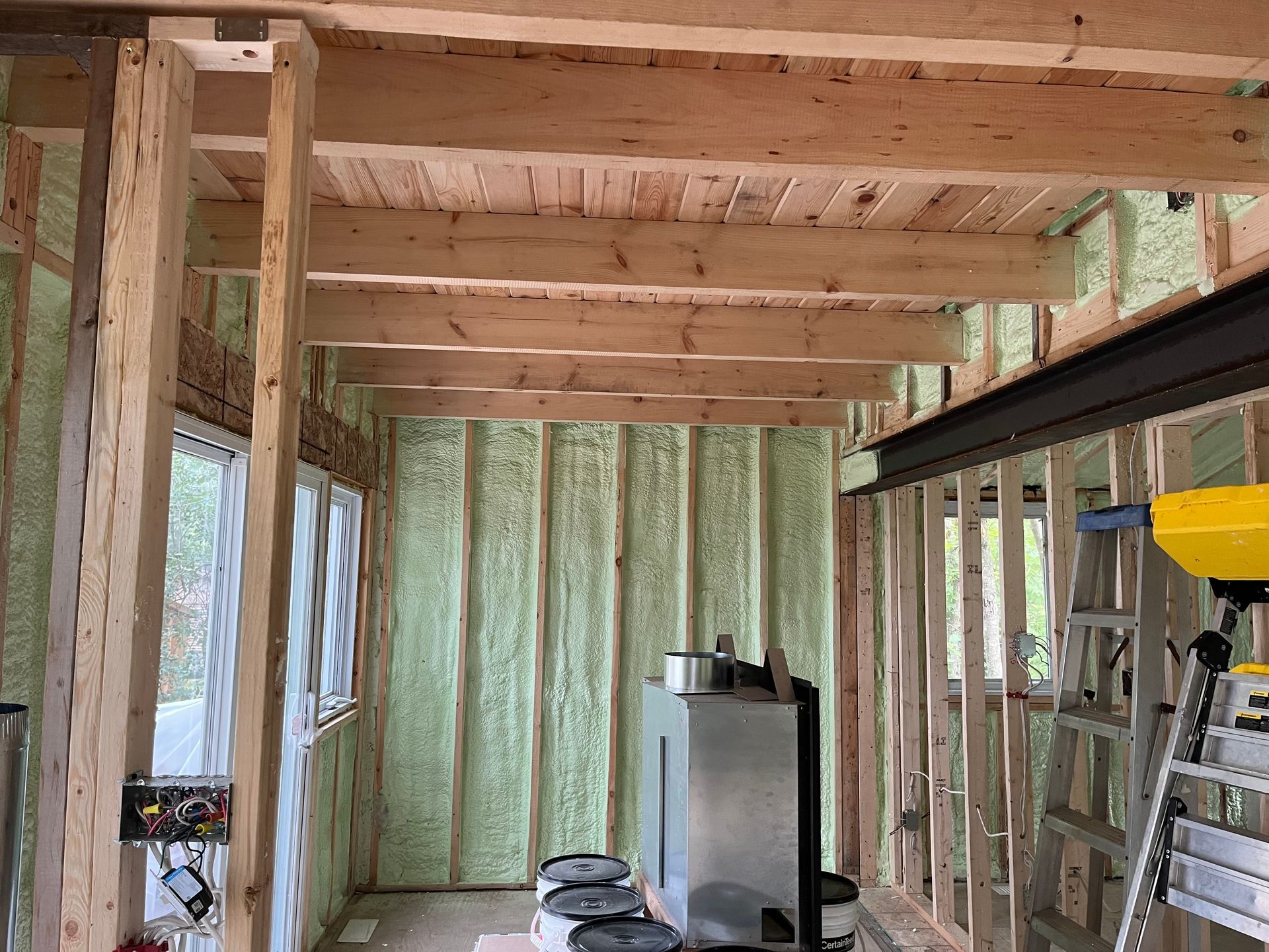 A room with a lot of wooden beams and a ladder.