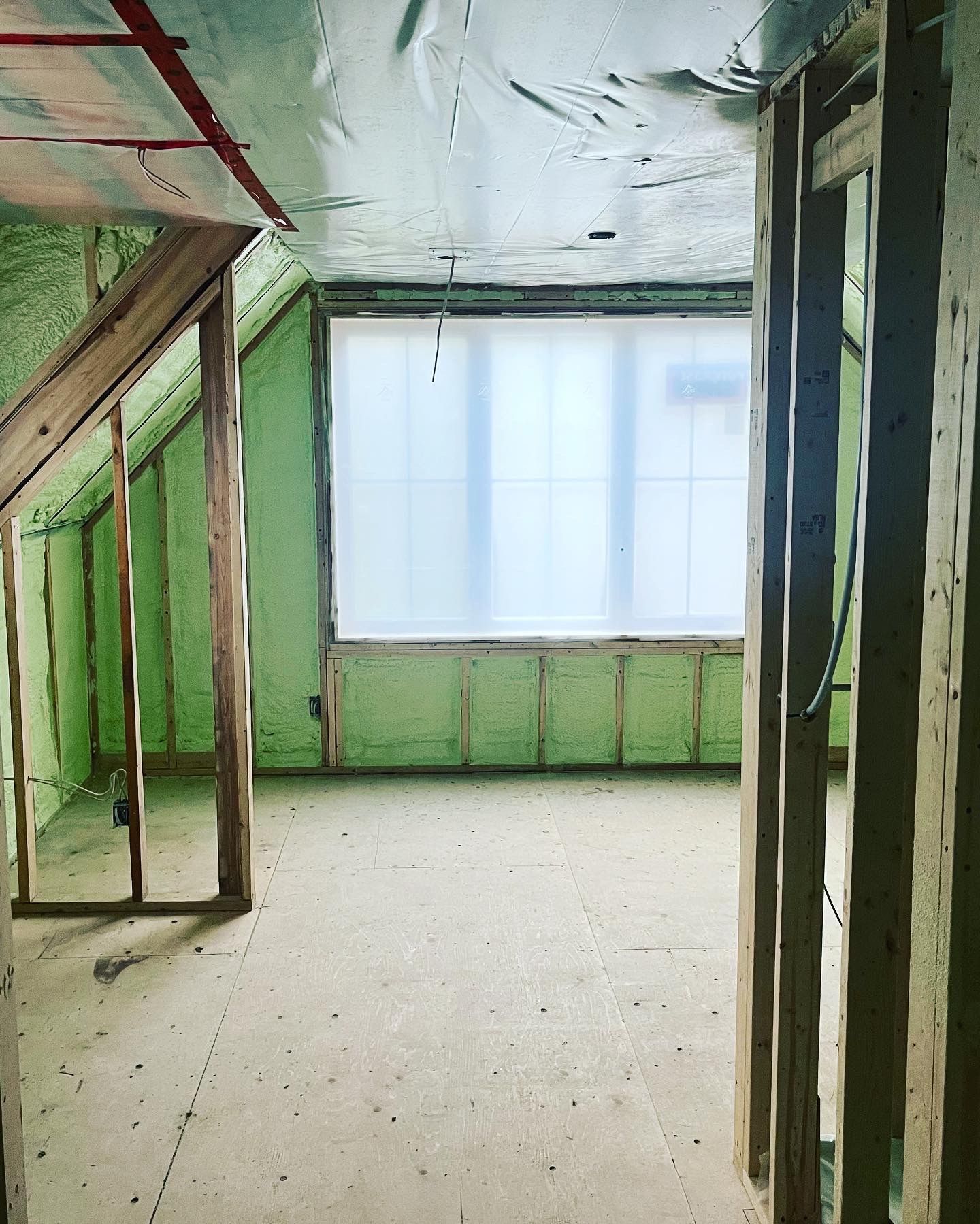 An empty room with green walls and a window