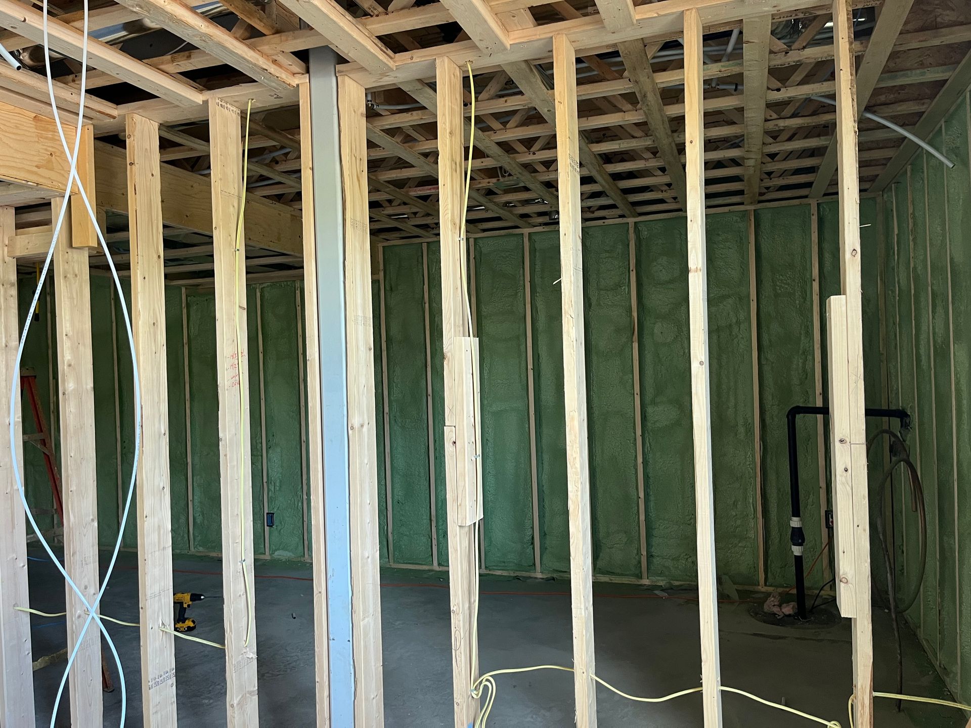 A room is being built with green insulation and wooden beams.