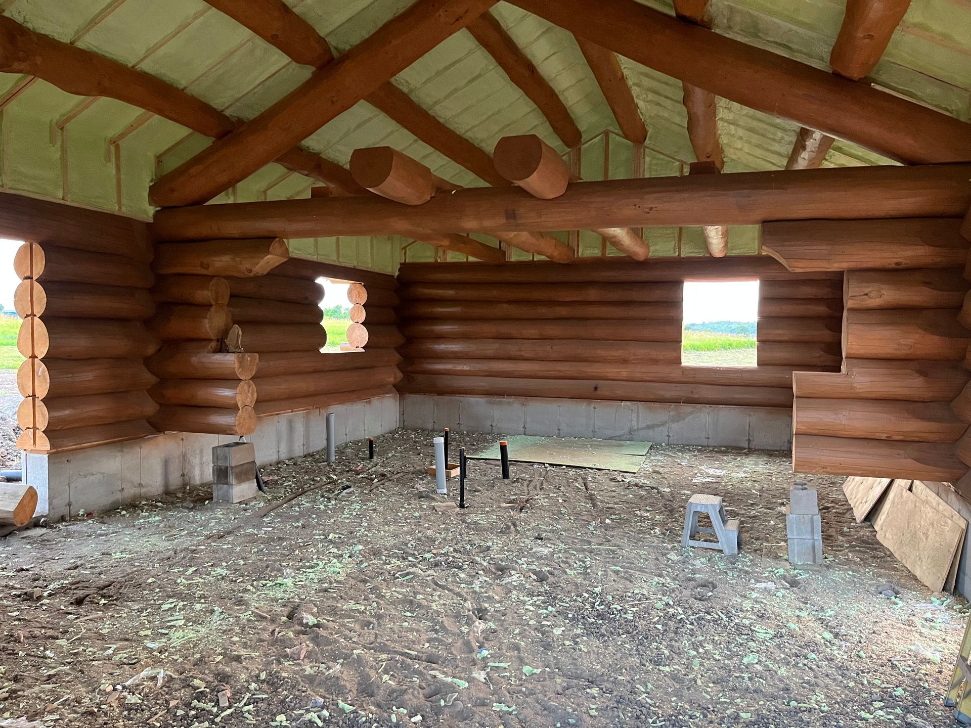 A log cabin is being built with a lot of logs