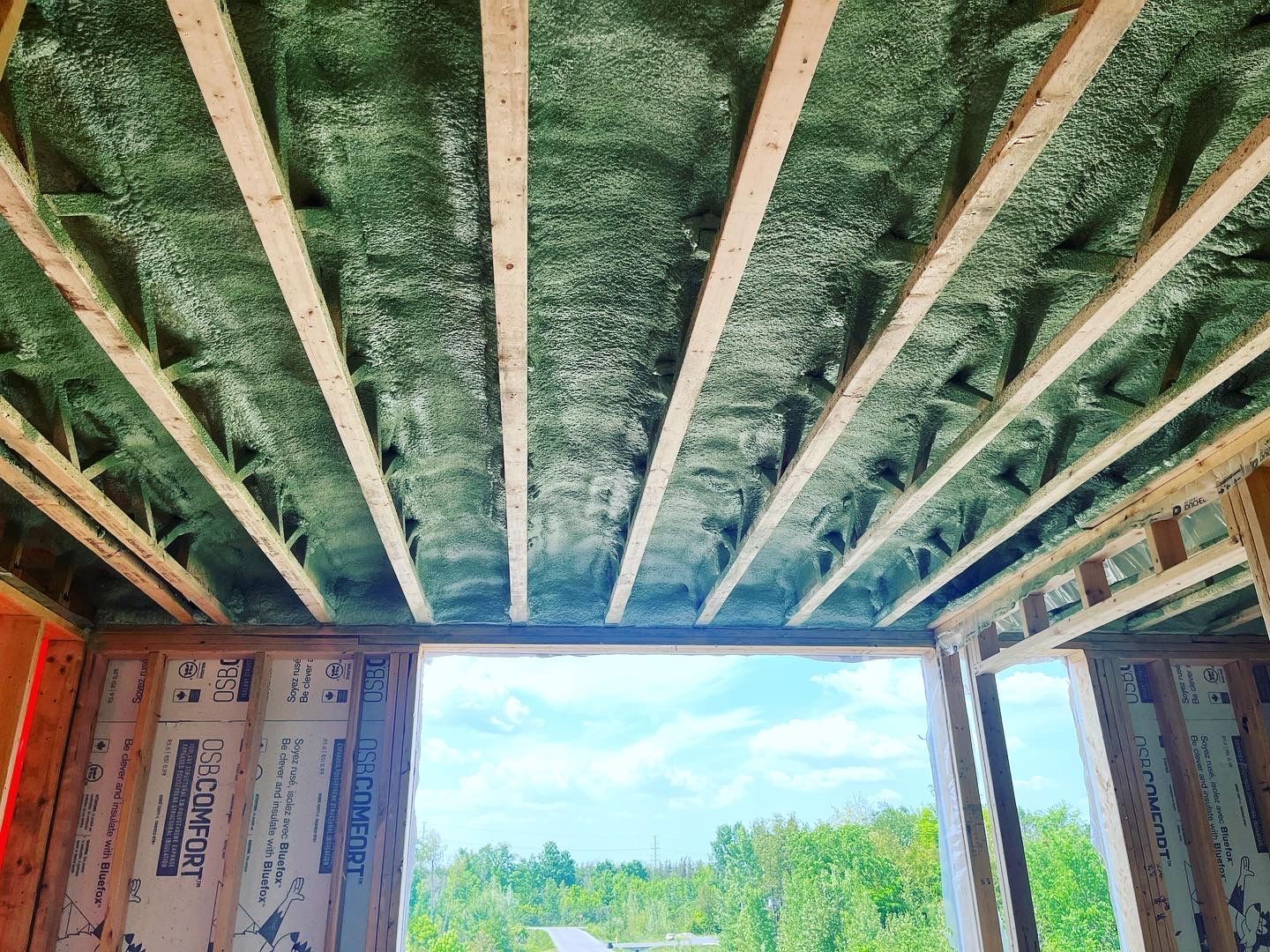 A room in a house under construction with a large window.