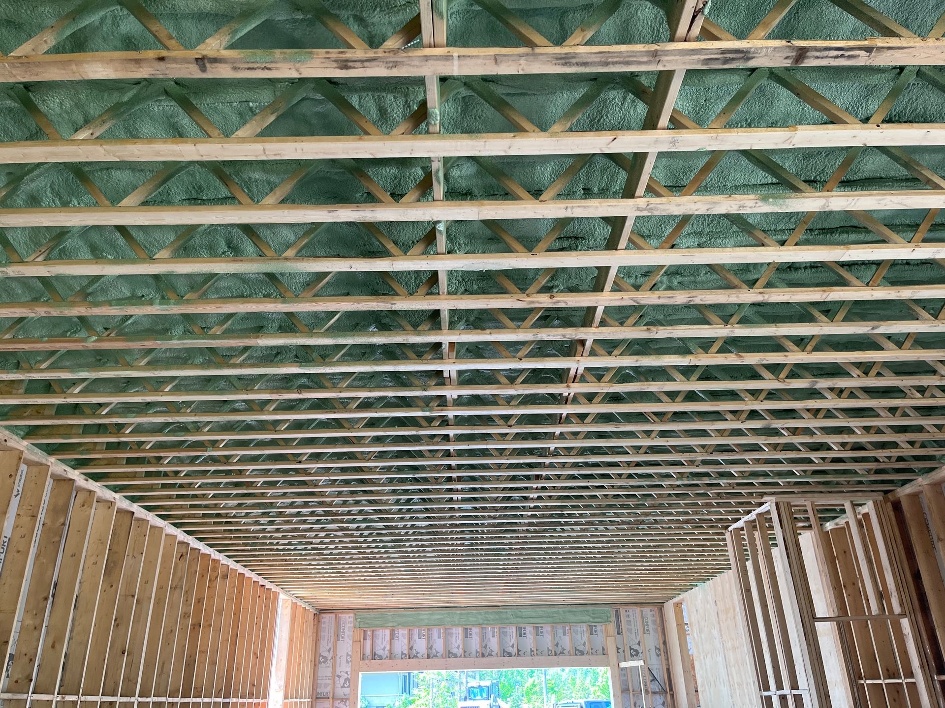 The ceiling of a building under construction with a lot of wooden beams.