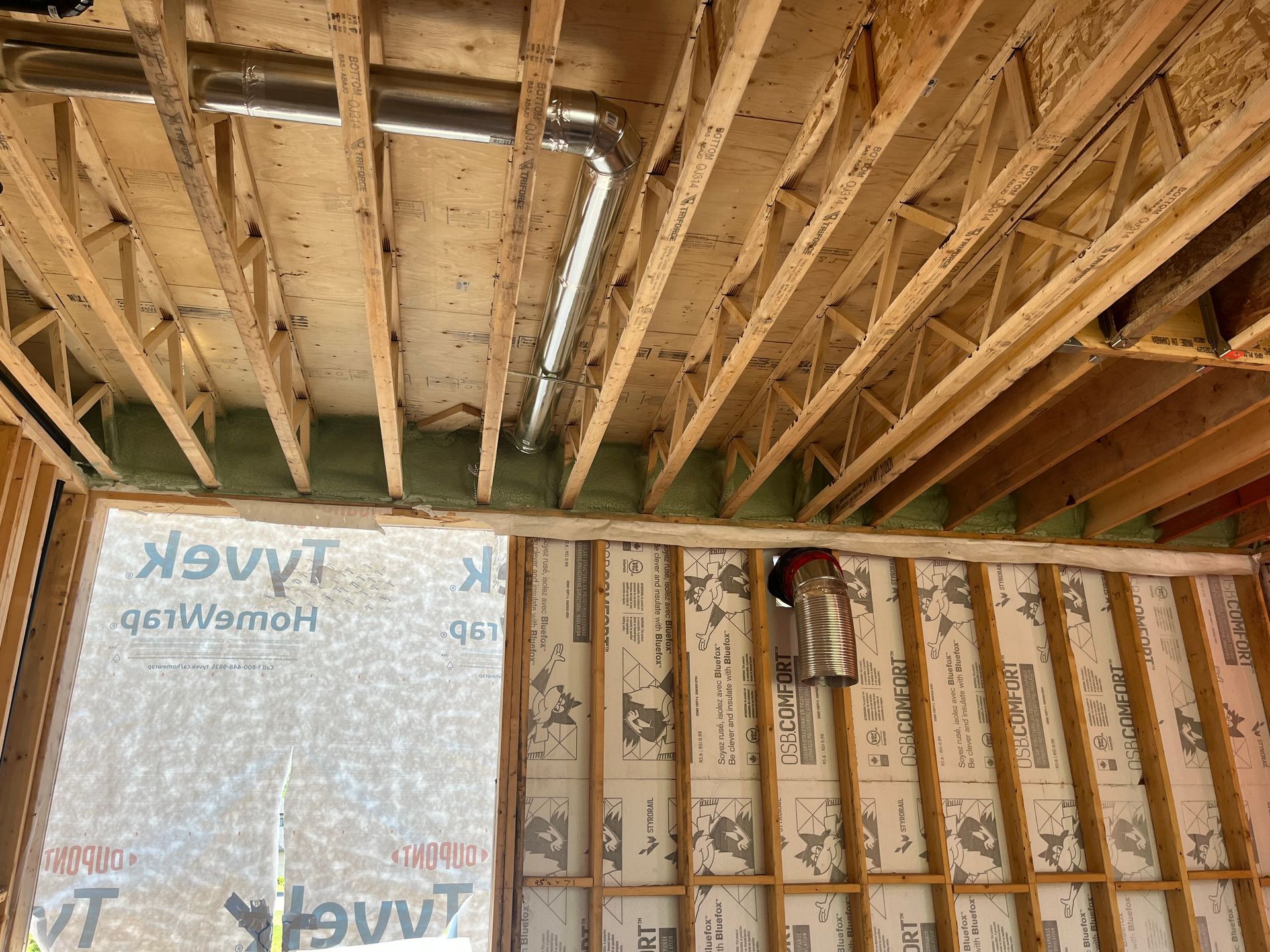 The ceiling of a house is being built and there is a pipe coming out of the ceiling.