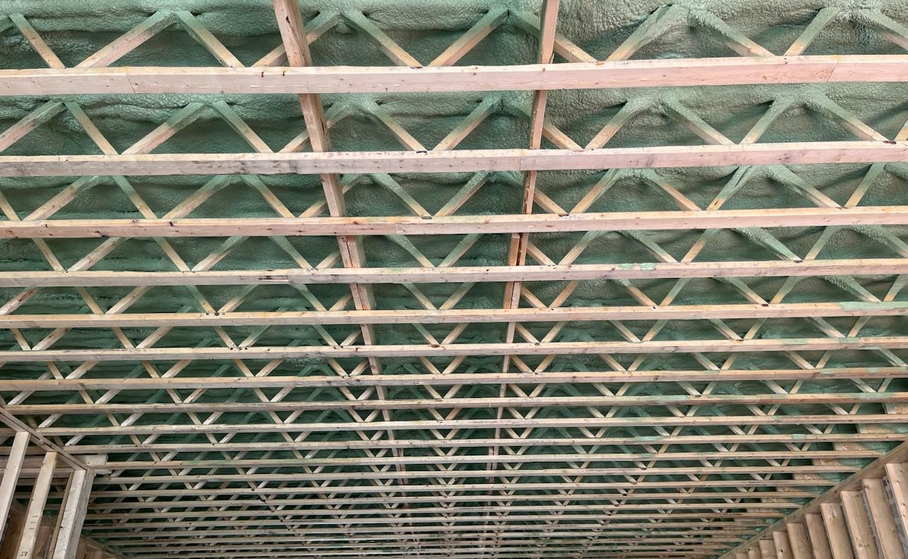 The ceiling of a building under construction with a lot of wooden beams.