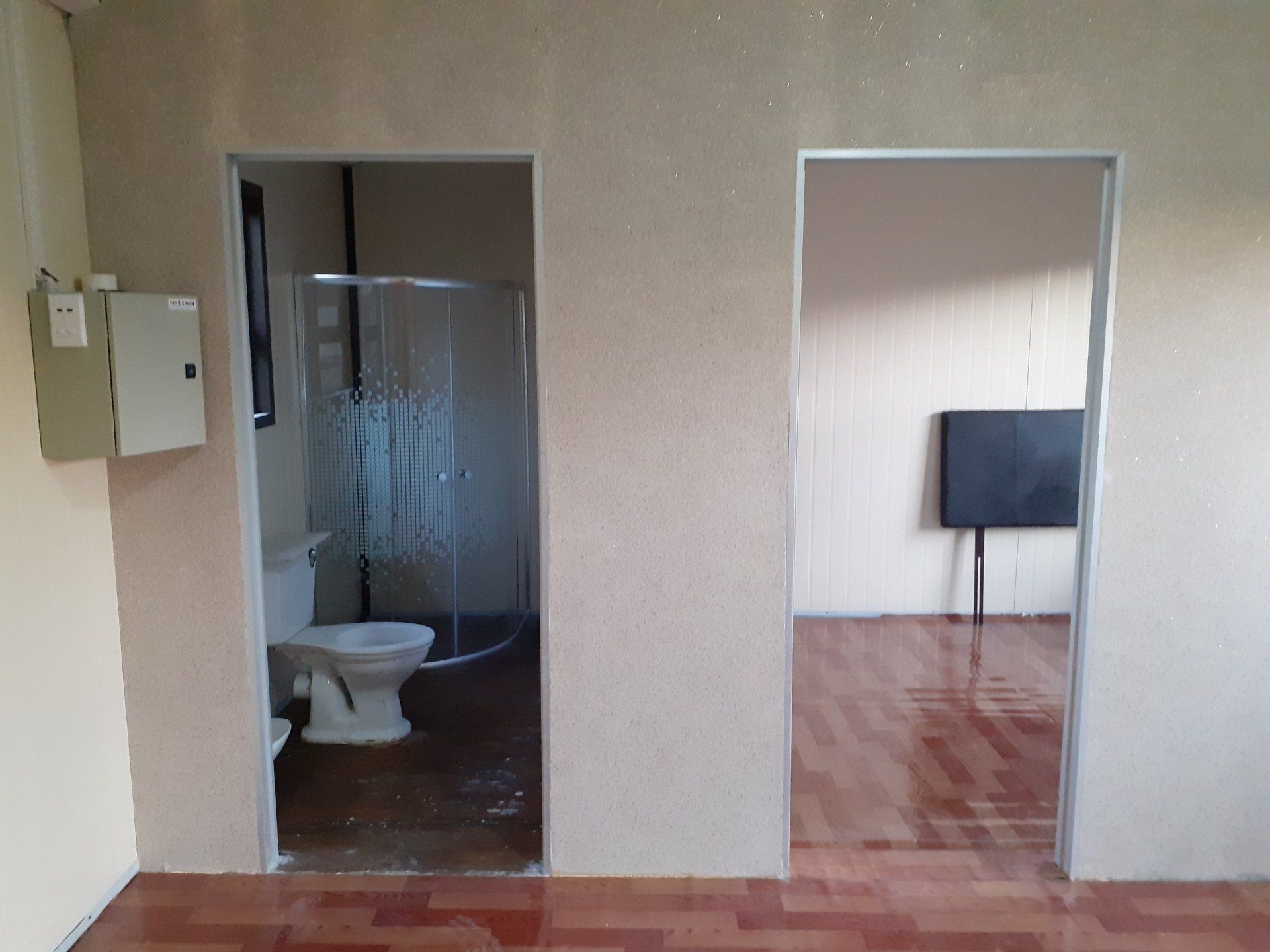 A bathroom with a toilet , sink and shower.
