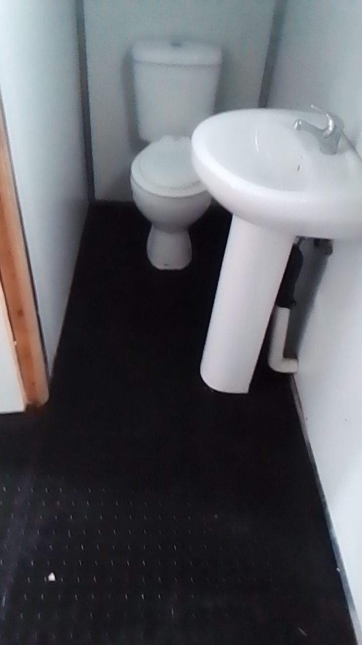 A bathroom with a toilet , sink and black floor