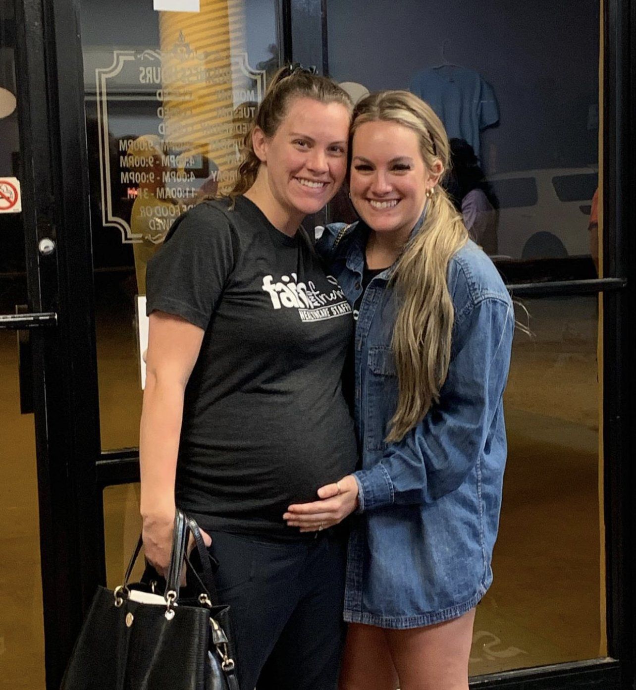Two women are posing for a picture and one is wearing a shirt that says family