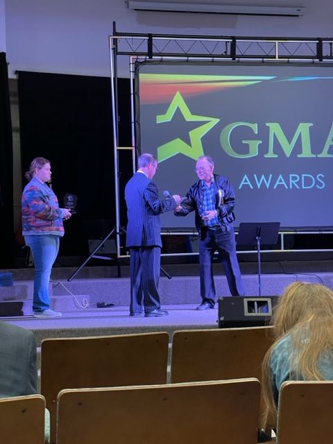 A group of people standing in front of a screen that says gma awards
