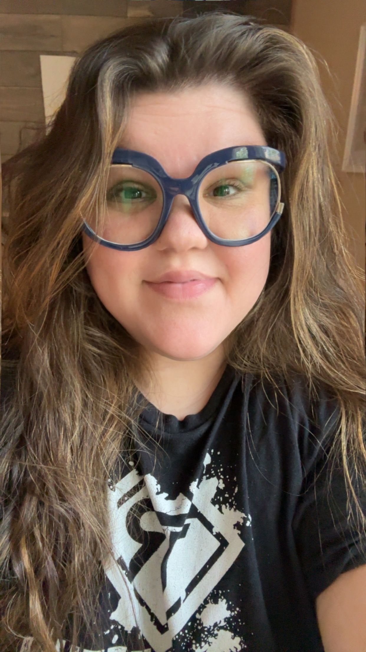 girl with long brown hair blue large glasses smiling