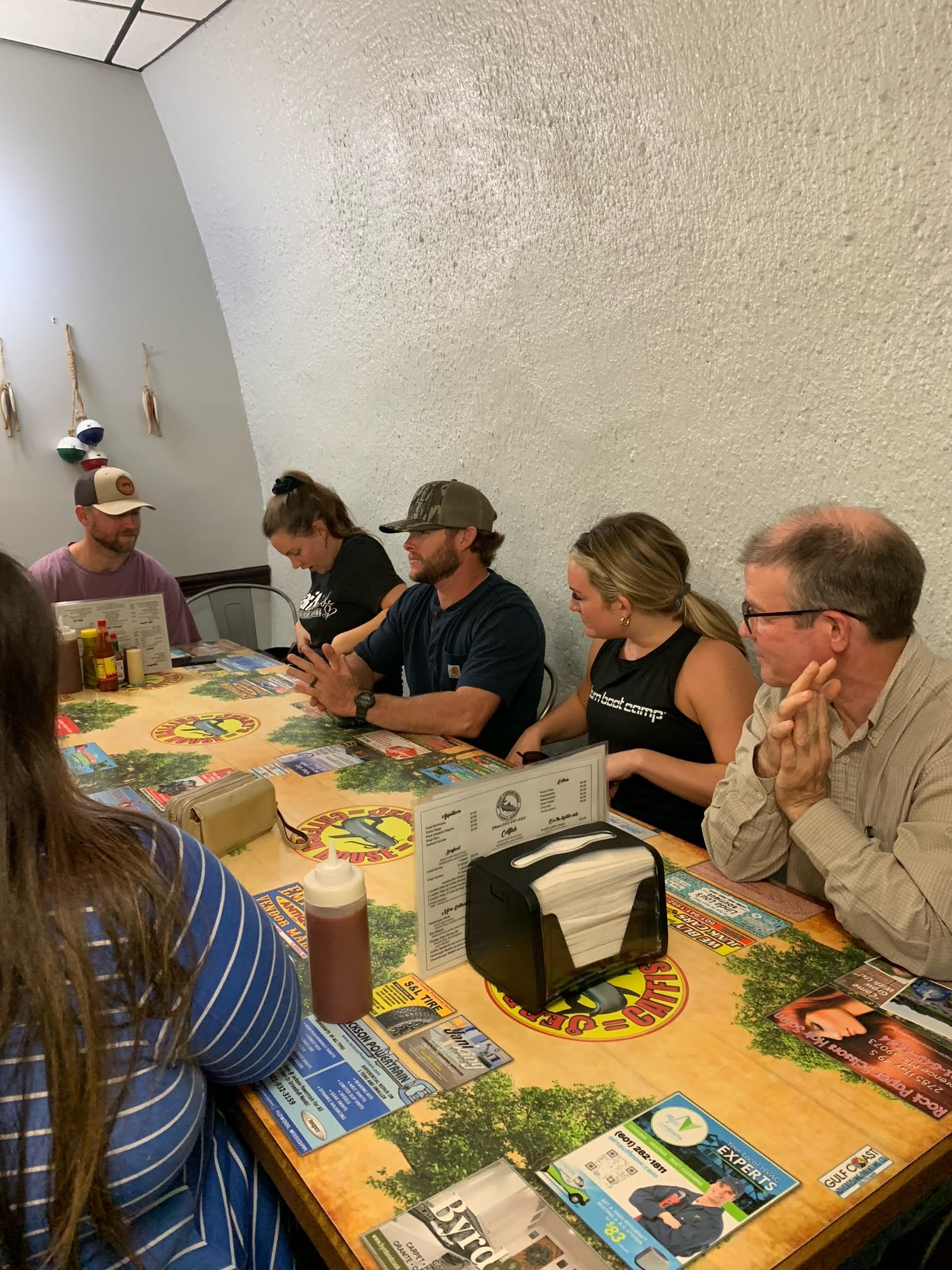 A group of people are sitting at a table in a restaurant.