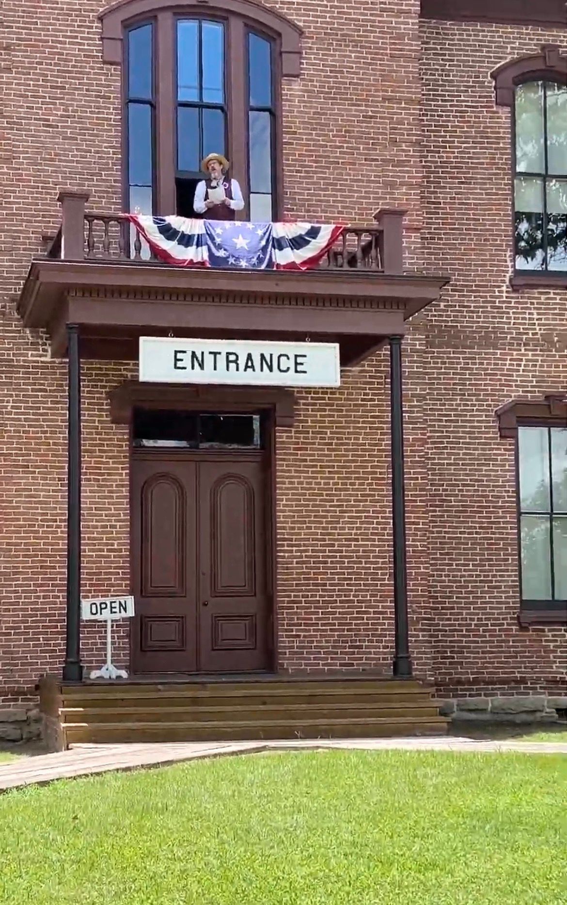 man on balcobny dressed up in red white and blue on a courthouse