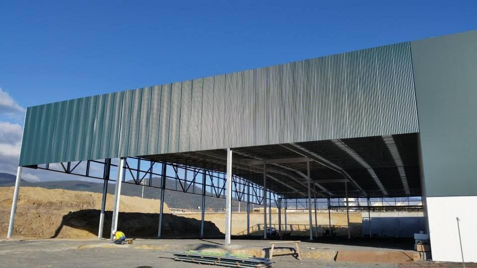 A large, open-sided industrial building under construction.
