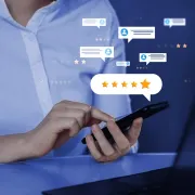 Person tapping smartphone with floating chat bubbles and star ratings on a blue background