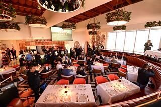 Una sala grande llena de mesas y sillas en un restaurante.