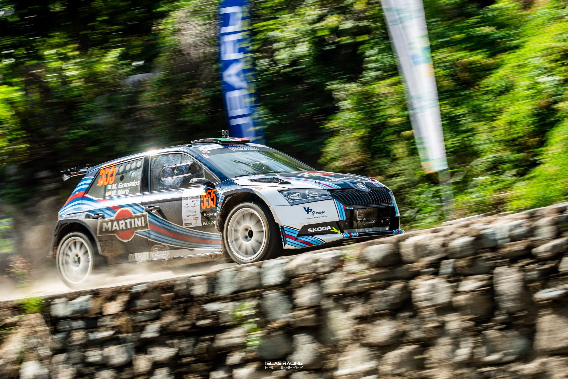 Un coche de rally desciende por una colina rocosa.