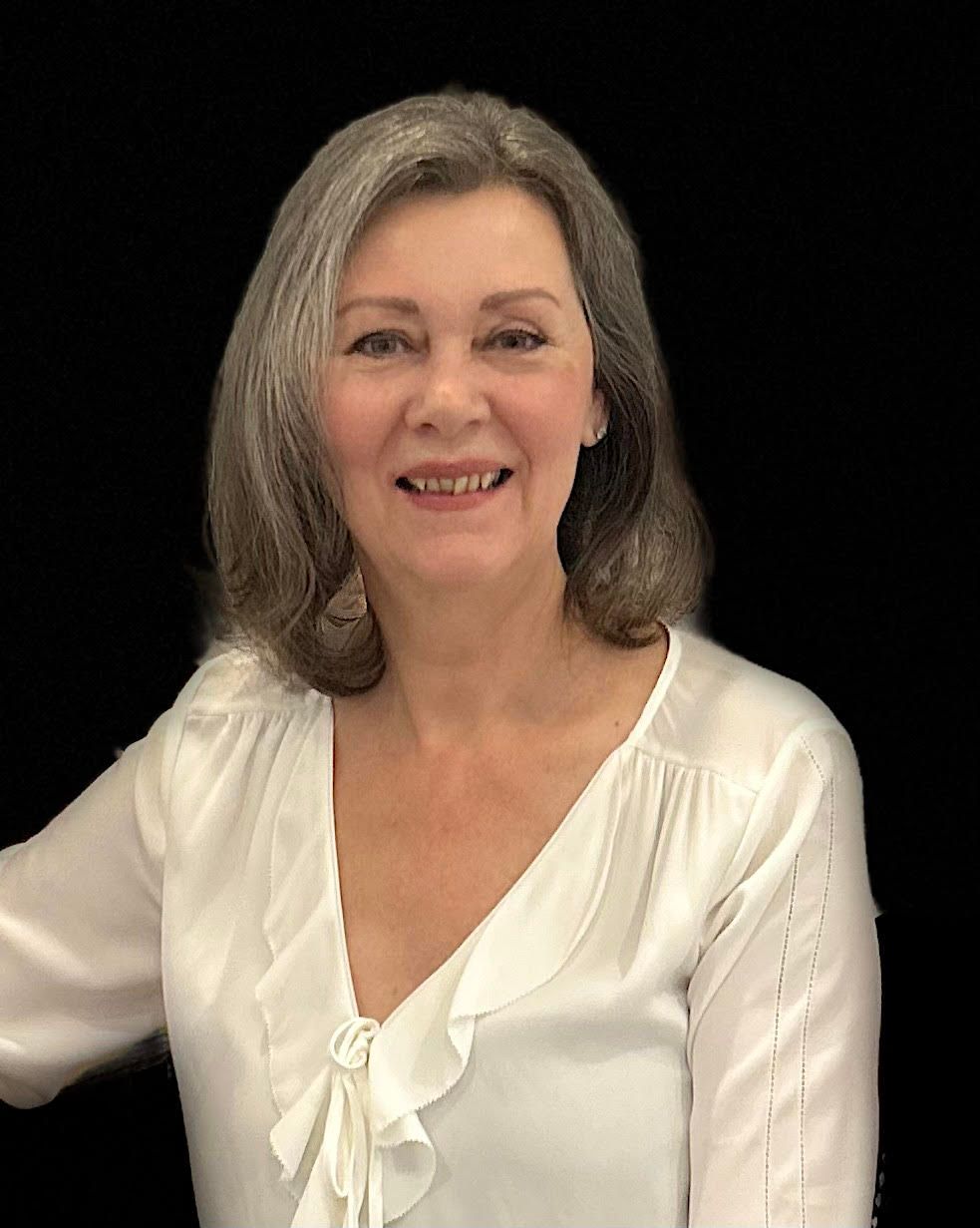 A woman is sitting at a table with her eyes closed.