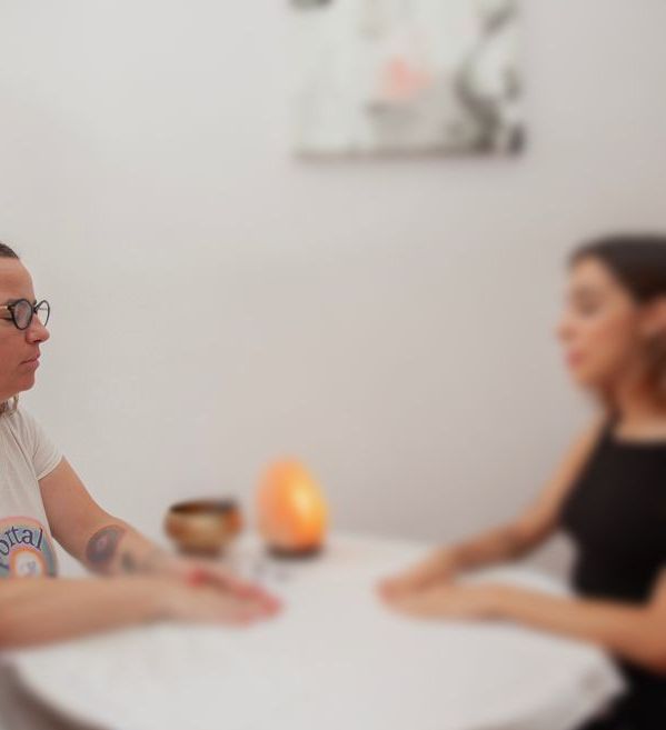 Una mujer está sentada en un sofá leyendo un libro.