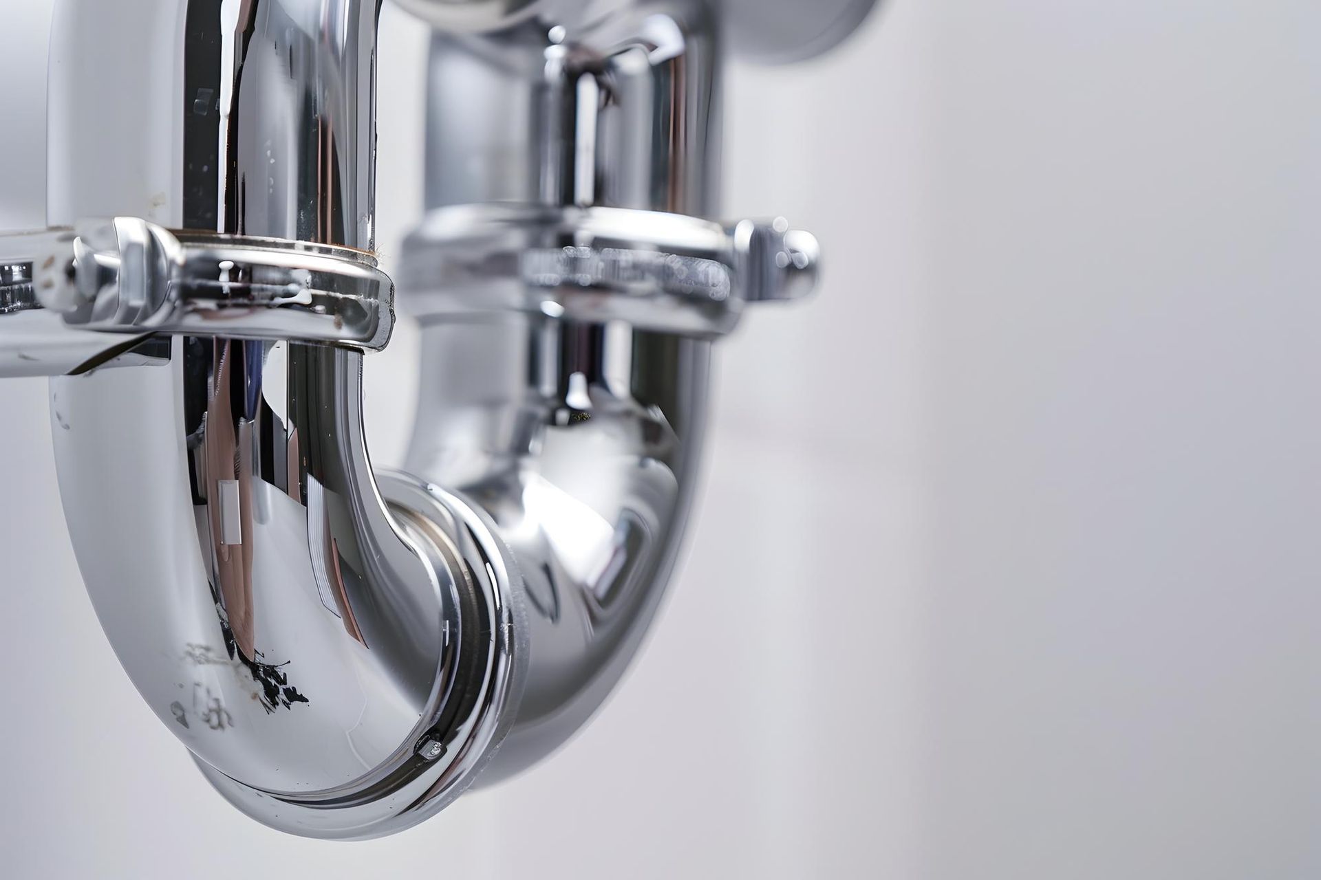 Chrome bathroom sink drain pipes under a basin