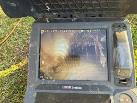 Rugged handheld monitor displaying a nighttime outdoor scene inside a black protective case.