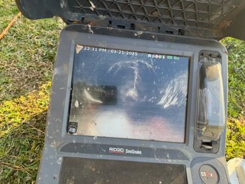 Rugged handheld device with a cracked screen inside a black protective case outdoors