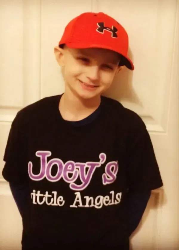 Boy wearing a red cap and black shirt with 