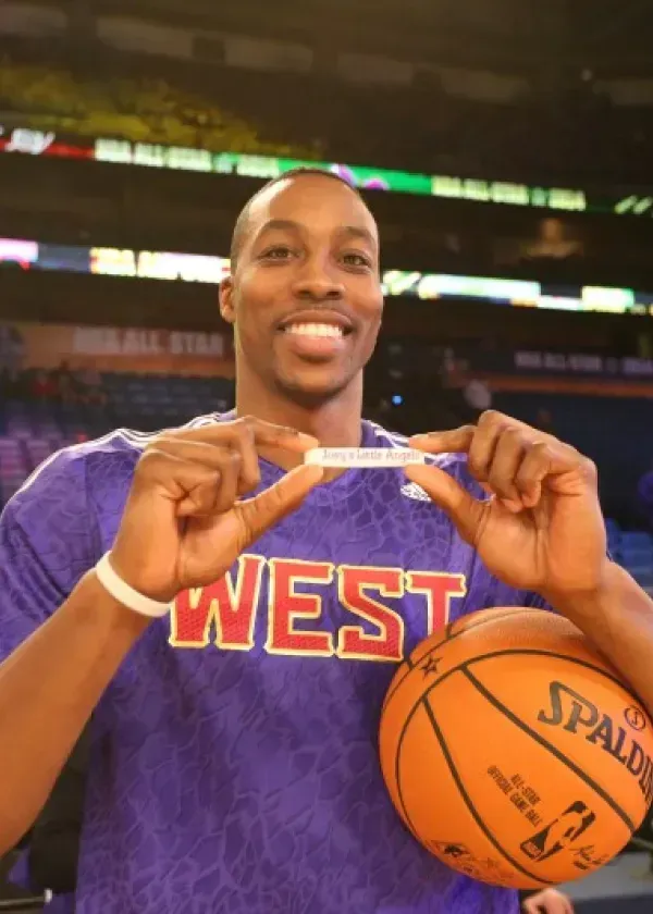 Dwight Howard holding a piece of paper, smiling, with a basketball and 
