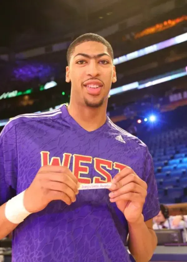 Basketball player Anthony Davis holding a card, wearing a purple 