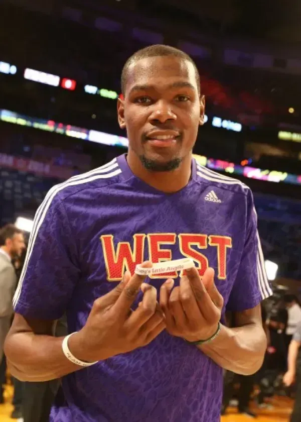 Kevin Durant holding an award, wearing a purple 