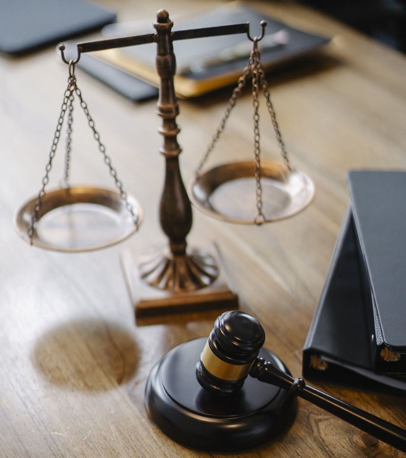 a scale of justice and a judge 's gavel are on a wooden table .