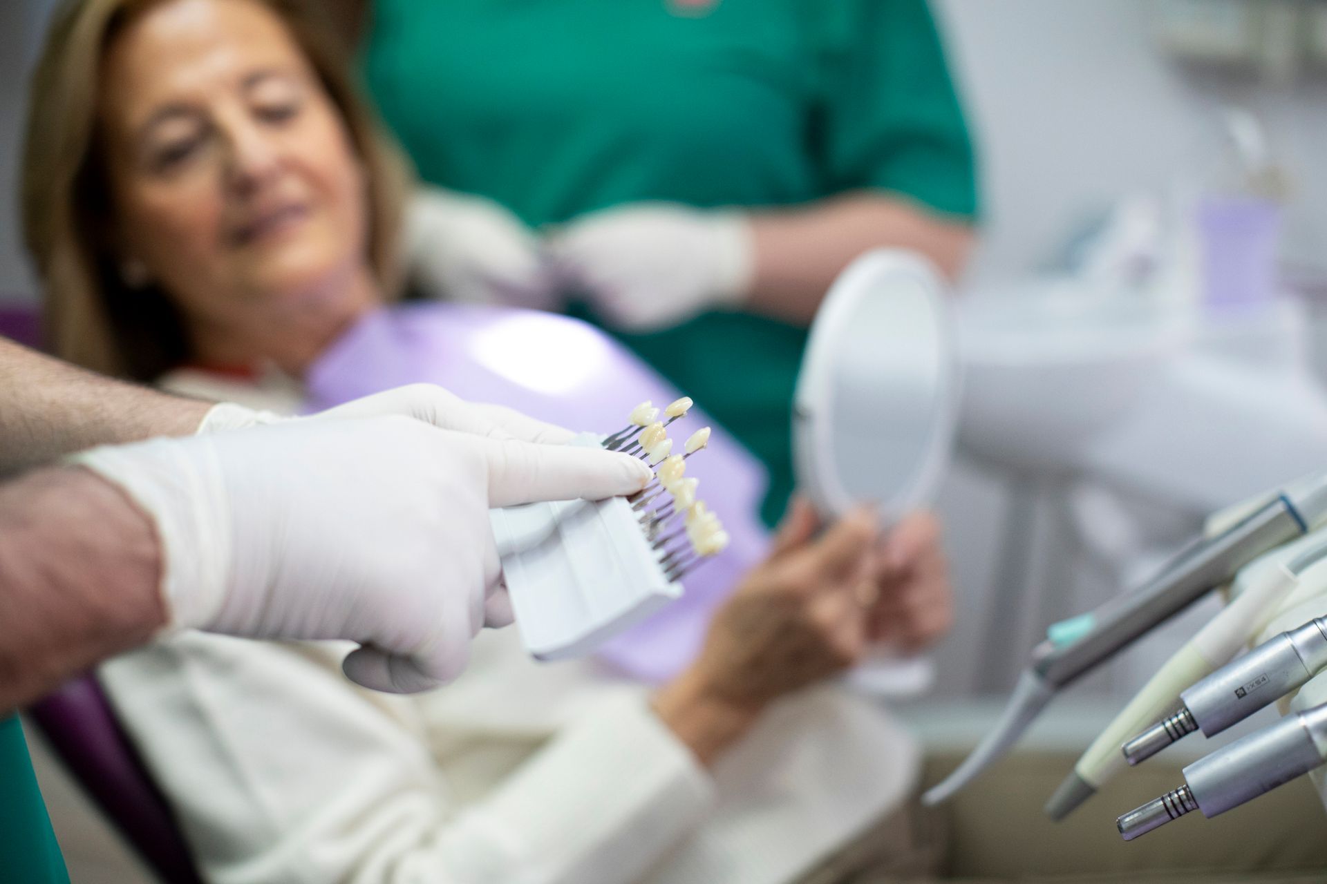 Dentist and patient selecting shade for local dental implants in a bright dental clinic setting.
