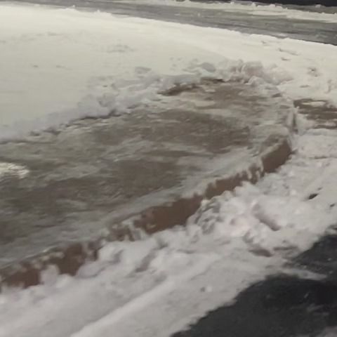 Snow-covered street with a slushy, partially cleared curbside edge