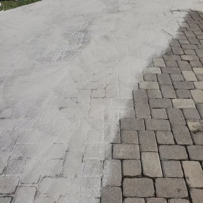 Gray concrete driveway beside a curved border of tan cobblestones