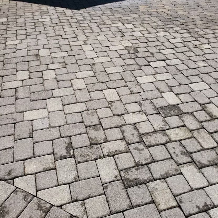 Gray cobblestone pavement with a few dark stones and a stone border at the top edge