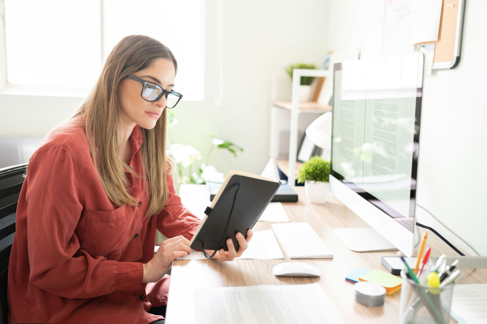 Person working at a desk with a tablet in a bright home office