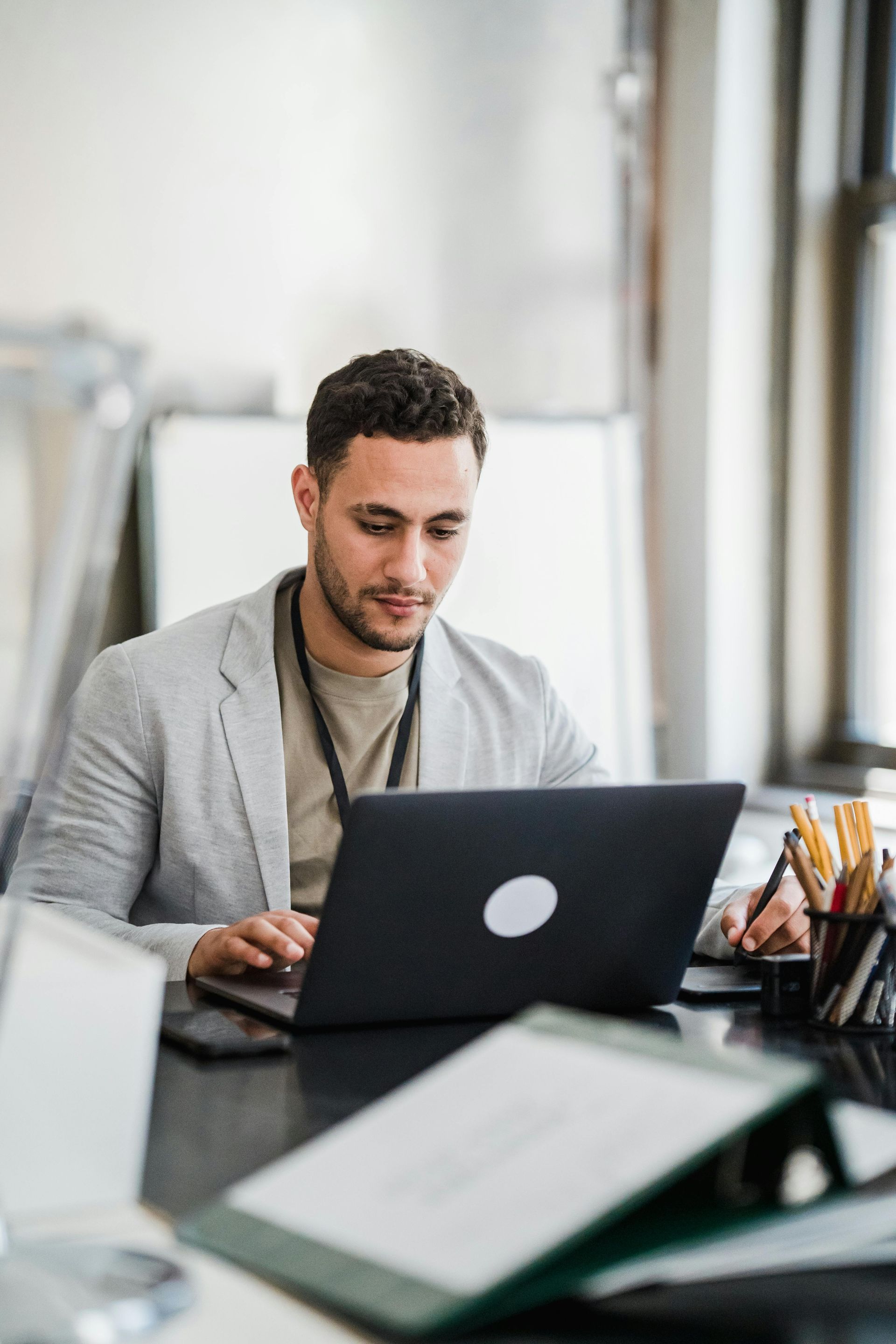 Person working on a laptop at a desk in a bright office
