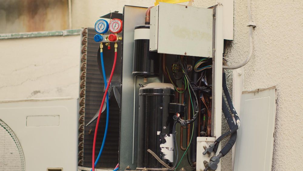 An air conditioner is being repaired on the side of a building.