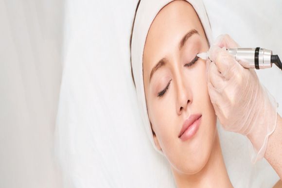 A person receiving a facial injection while lying down with eyes closed with Amanda B Beauty and Brows. 