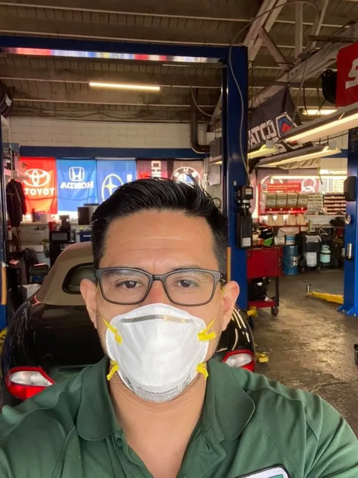 Man wearing a mask and glasses in an auto repair shop. | Golden Gear Automotive